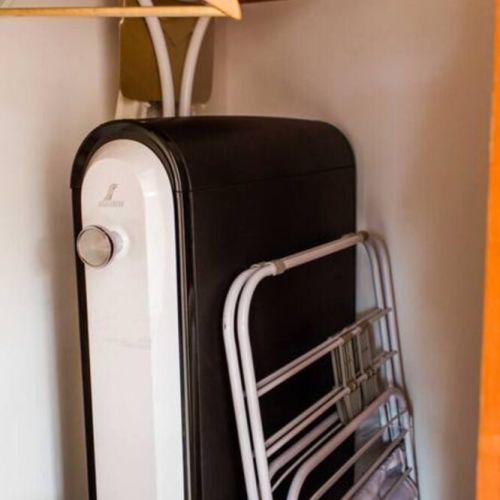 Ironing board, suit cleaner, and drying rack stored in the second bedroom closet.