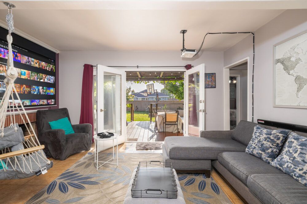 Living room with projector and French doors into backyard