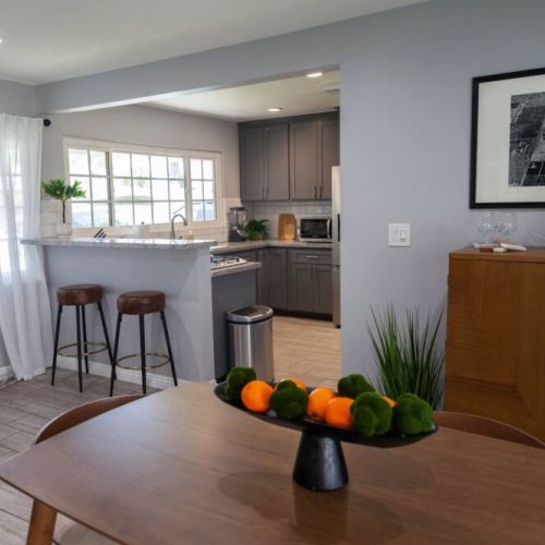 Great dining room with a table for 6 and 2 stools at the counter. A beautiful bar is available with wine for you to enjoy. A coffee bar is strategically placed as you walk into the dining room. Great windows to view the front yard & people watch.