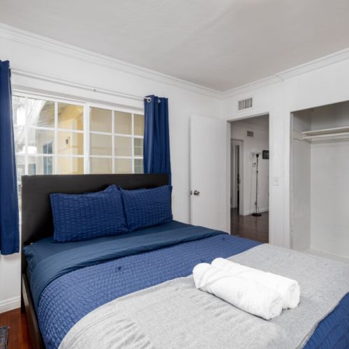 Second bedroom furnished with a queen-sized bed, closet, and attached bathroom.