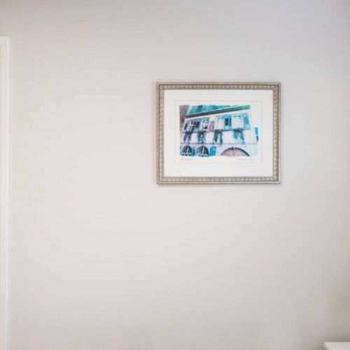 Wall art in second bedroom with nightstand lamp.