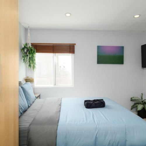 Second bedroom furnished with queen-sized bed and 4K Smart TV
