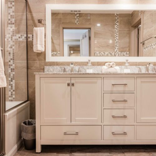 Master bathroom with his and hers sinks, bathtub, and separate attached room for the loo.