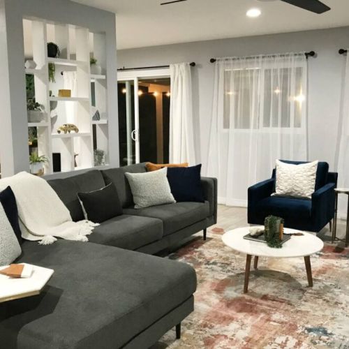 Living room view to the dining room and backyard patio with lights on in the evenings.