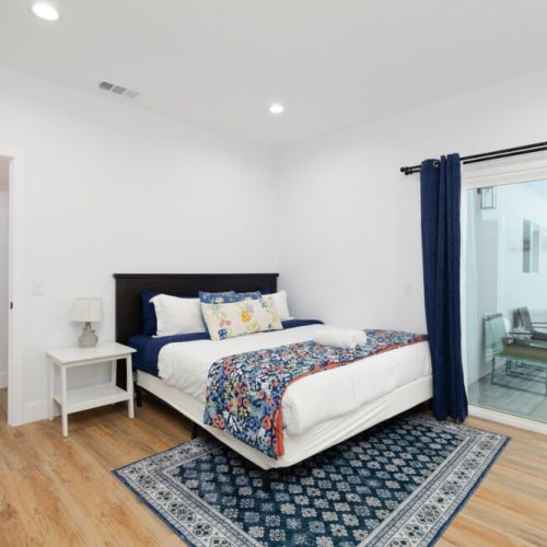 Master bedroom furnished with a king-sized bed, ambiant lighting, en-suite bathroom, and walk-in closet.. AND an outdoor patio!