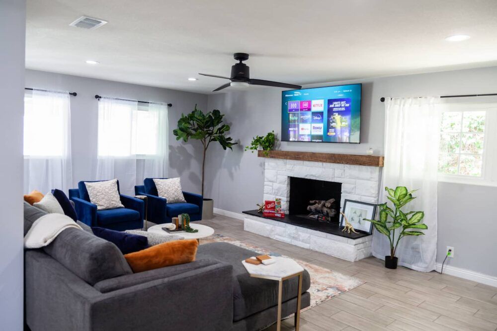 Great living room space to relax and watch a movie on the 65 in Roku TV. Awesome natural light comes through large windows.