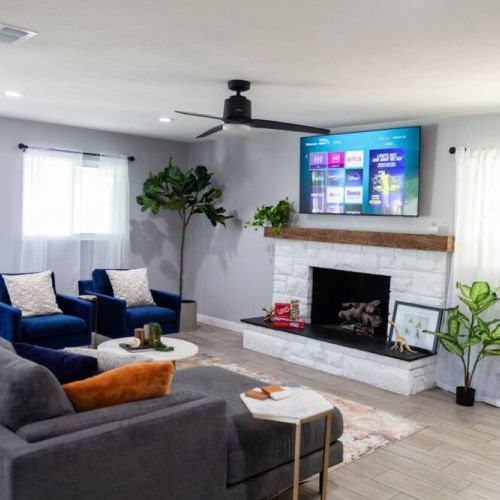 Great living room space to relax and watch a movie on the 65 in Roku TV. Awesome natural light comes through large windows.