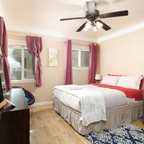 Third bedroom furnished with a queen-sized bed, desk, plenty of storage, and a 4K Smart TV!