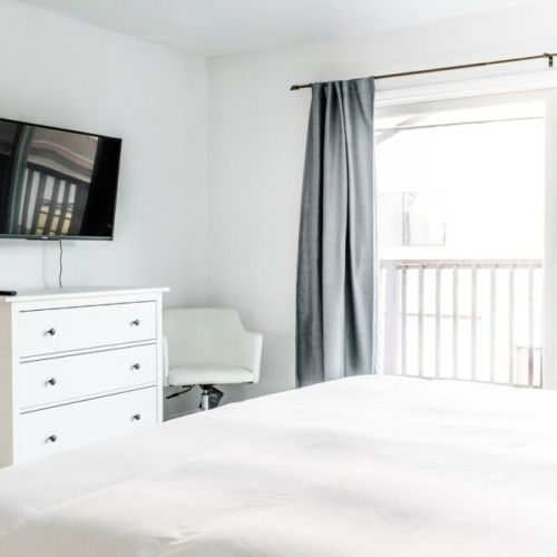 Master bedroom with dresser and 4K Roku Smart TV