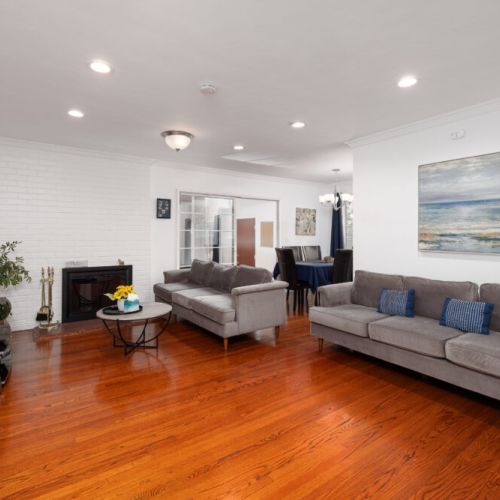 Living room has plenty of seating and a cozy wood-burning fireplace.