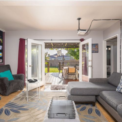 Living room with projector and French doors into backyard