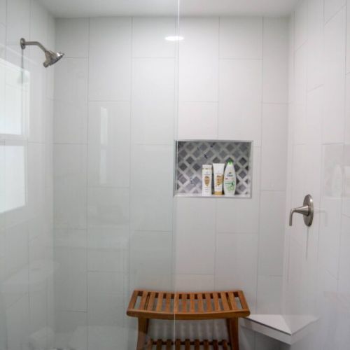 2nd bathroom with a large walk-in shower with a teak bench for sitting.