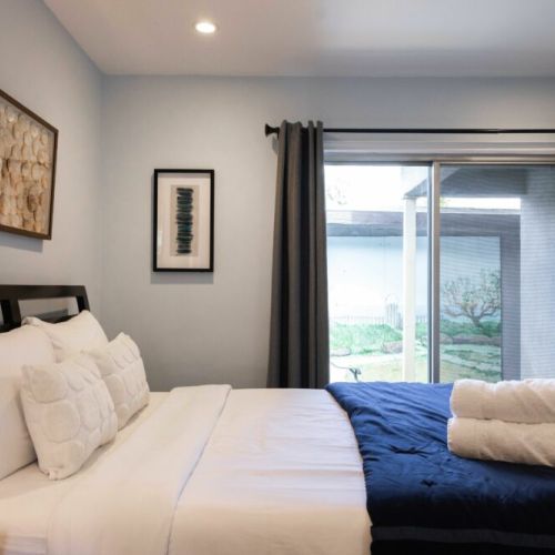 Bedroom furnished with a queen bed and attached private patio
