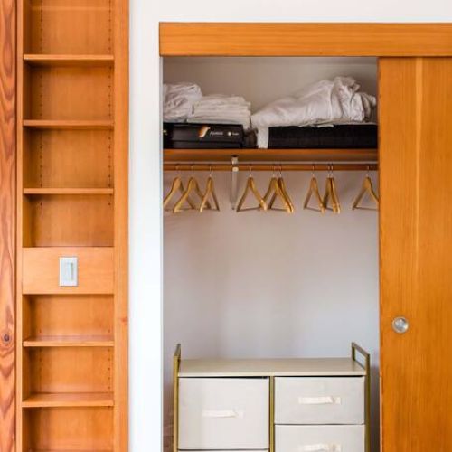 Small dresser, hangers, and extra sheets stored in the second dresser closet.