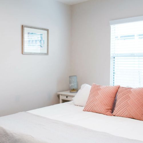Second bedroom furnished with pinks and whites with a king-sized bed