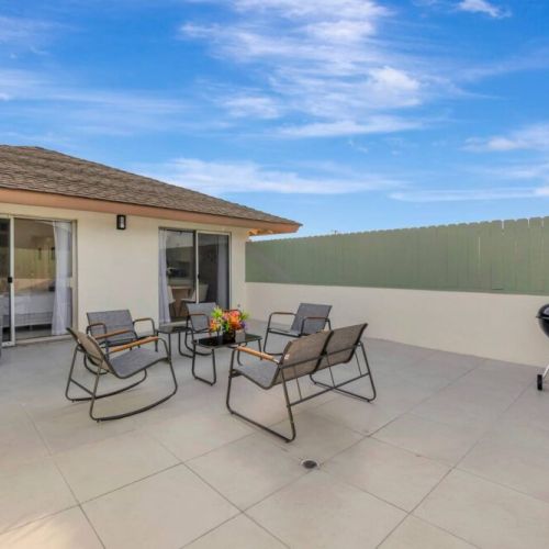 Enjoy the relaxing ambiance of The Floral Terrace in sunny Southern California, complete with a grill and comfortable patio furniture—ideal for family gatherings and BBQs in the perfect outdoor setting.