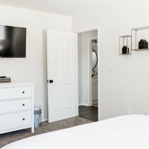 Master bedroom furnished with a Smart 4K TV, dresser, and walk-in closet.