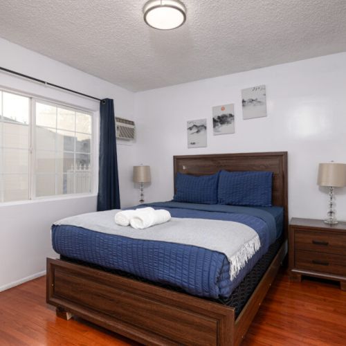 Third bedroom furnished with a queen-sized bed, two night stands, and lamps for perfect evening light.