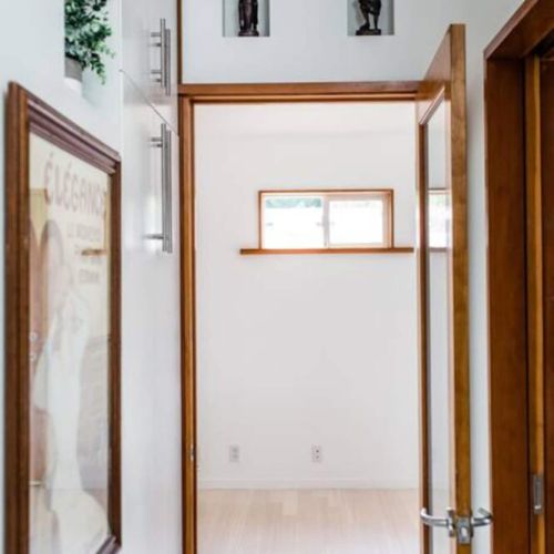 Hallway from the kitchen to the second bedroom. Hallway cabinet with extra supplies (cleaning items, space heaters/fans, towels, iron, etc.) is on the left.